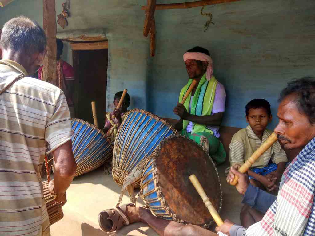 A few men gearing up with their Dhamsa for a music and song performance, outside the courtyard of a mud house.