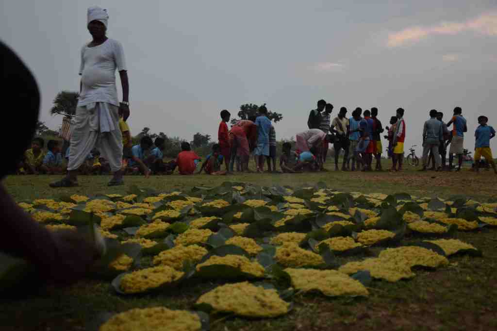 Peetha from homes lay on leaf plates in an open ground, with children waiting in the background.